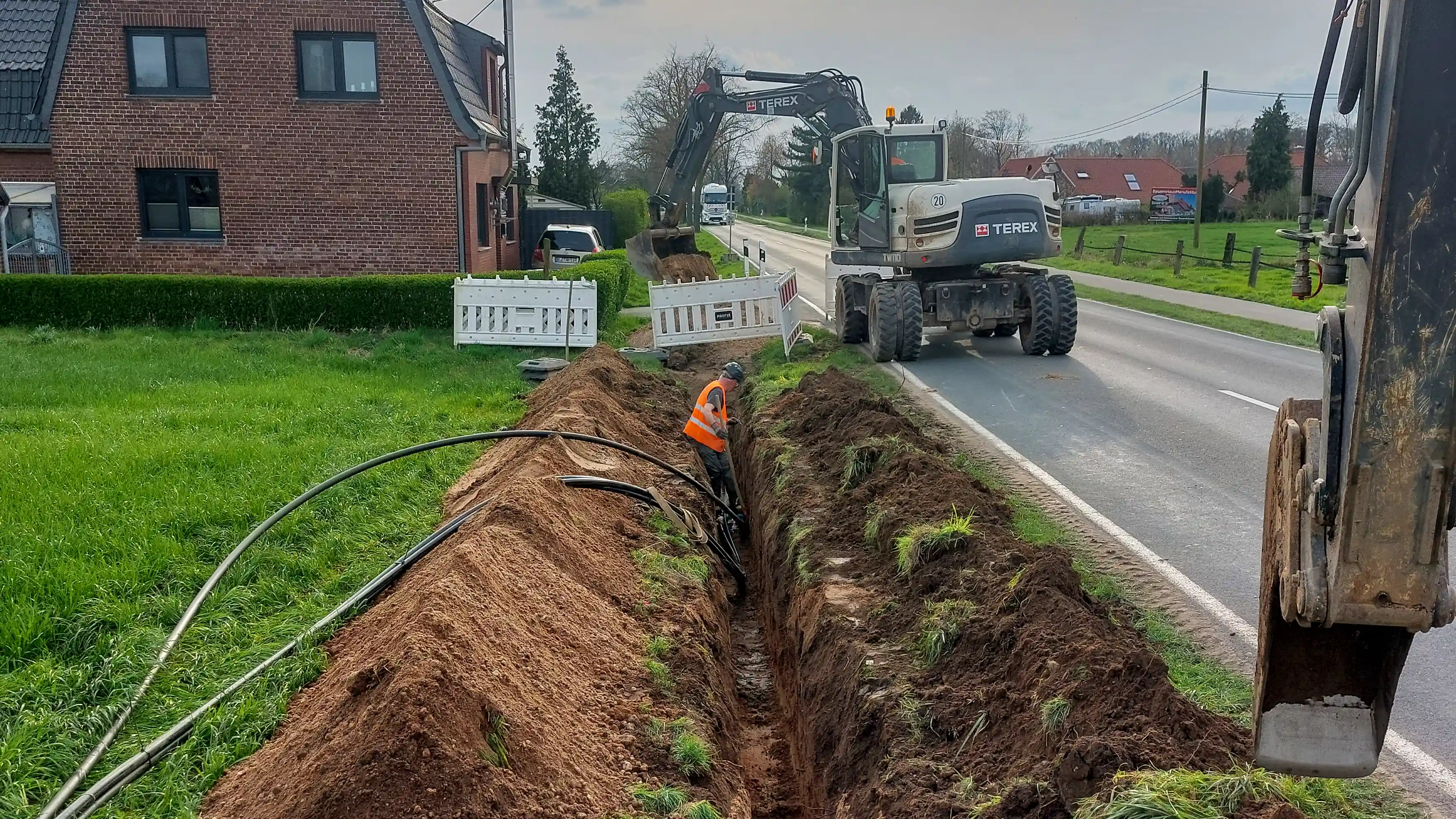 Kabelleitungsbau am Straßenrand mit Baggern